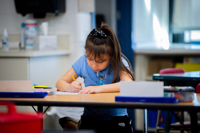 Student in classroom working on assignment.